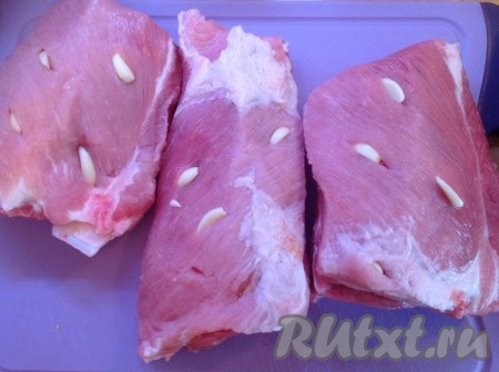 Теперь нашпигуем свиные рёбрышки чесноком.