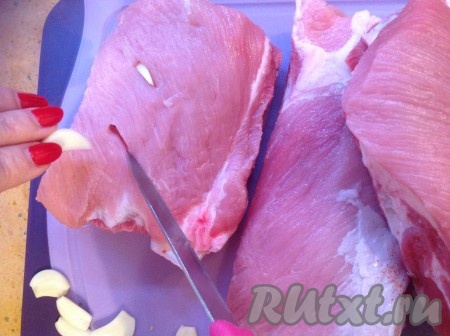 Теперь нашпигуем свиные рёбрышки чесноком.