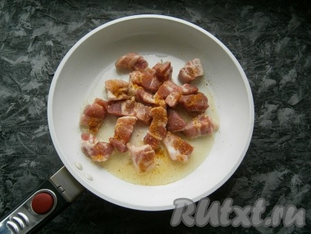 Сковороду разогреть с растительным маслом, выложить кусочки свинины, посыпать специями.