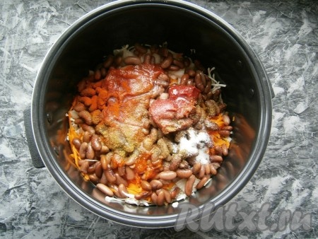 Далее выложить фасоль, добавить томатную пасту и томатный соус, всыпать соль, черный молотый перец, паприку, сахар и хмели-сунели, влить растительное масло.
