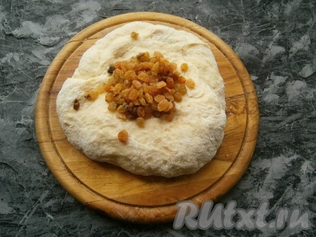 На стол насыпать оставшуюся муку, выложить тесто и немного его "подмешать", оно будет гладким, нежным и чуть липнущим. Теперь добавить изюм (если сухой - предварительно замочить его в кипятке на 10 минут, а затем обсушить).&nbsp;
