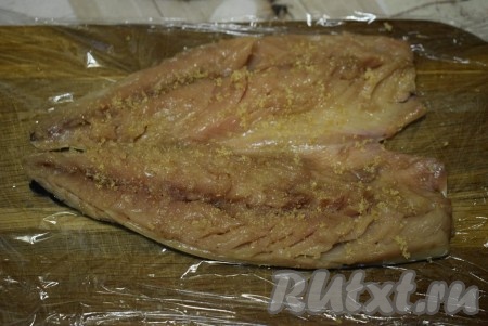 Подготовленное филе скумбрии солим и перчим по вкусу, при желании, можно сбрызнуть рыбу лимонным соком, но я этого не делала. Оставляем скумбрию пропитаться и просолиться на 15-20 минут. Разделочную доску выстилаем пищевой пленкой. Выкладываем на пленку рыбу кожей вниз. Филе равномерно посыпаем половиной чайной ложки желатина.

