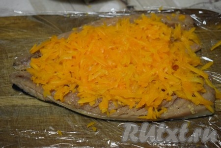Затем вареную очищенную морковь натираем на крупной терке и выкладываем на рыбу. Слегка присаливаем морковь и равномерно посыпаем оставшимся желатином.
