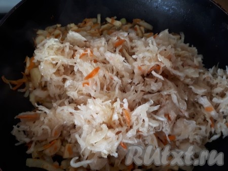 Затем на сковороду с овощами добавить квашеную капусту и продолжать обжаривание. Капуста должна стать мягкой и более темного цвета. Во время тушения капусты, если необходимо, добавить небольшое количество воды.
