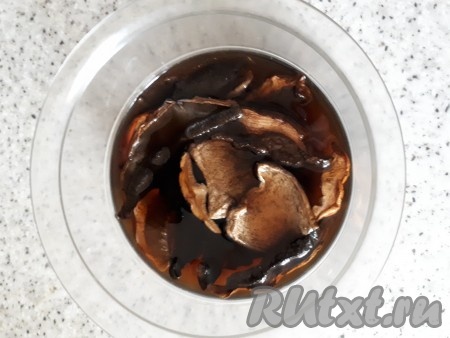 Сушеные грибы залить кипятком и оставить до размягчения.