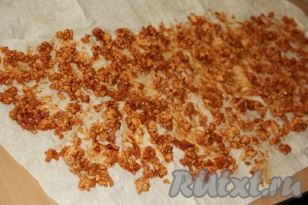 Разложить лист лаваша и выложить на него начинку, оставляя края лаваша чистыми. Равномерно разровнять мясную начинку.
