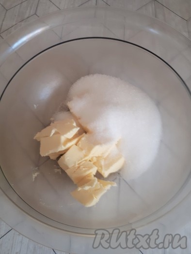 Продукты для приготовления кекса должны быть комнатной температуры. Если творог неоднородный (крупинками), его нужно протереть через сито или пропустить через мясорубку. Выложить изюм в небольшую ёмкость, залить полностью кипятком, оставить минут на 5, после этого воду слить, обсушить изюм, разложив его на бумажном полотенце. Сливочное масло комнатной температуры выложить в объёмную миску, всыпать сахар, растереть вилкой до однородности.