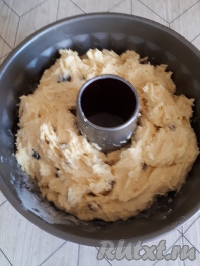 Форму для кекса с дыркой смазать растительным маслом, припорошить мукой. Выложить тесто в форму.