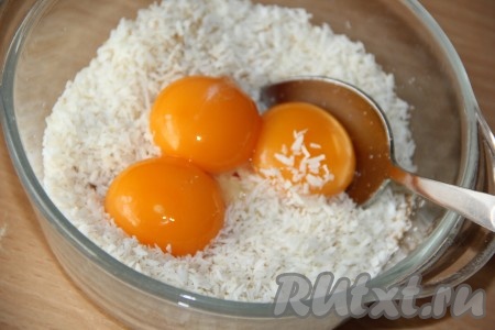 Соединить кокосовую стружку, сахар, ванильный сахар и желтки, тщательно перемешать ложкой.