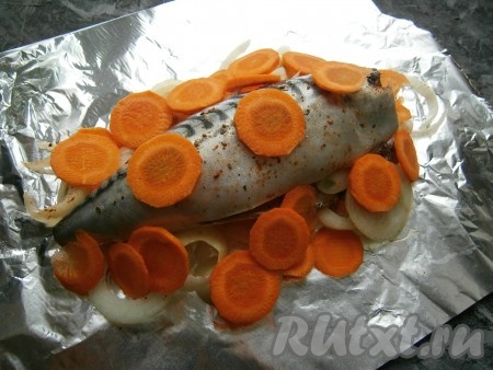 Лук и морковь очистить. Лук нарезать кольцами, морковь - кружочками. На лист фольги, сложенный вдвое-втрое, выложить лук, на него - скумбрию, сверху и по краям разместить кружочки моркови.
