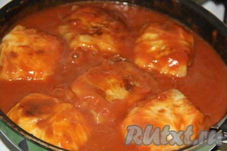 Влить соус в сковороду с голубцами, довести до кипения, уменьшить огонь и томить 15 минут.
