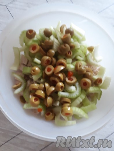 Оливки нарезать колечками и добавить в салат из курицы и сельдерея.
