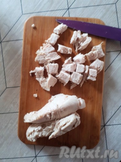 Остудить курицу в воде, в которой она варилась.

Остывшую куриную грудку нарезать на кубики.