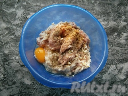 Перекрутить кусочки мяса вместе с очищенным луком на мясорубке (или измельчить в чаше блендера). Выложить получившийся фарш в миску, добавить сырое яйцо, измельченный чеснок, соль, а также специи и чёрный молотый перец, тщательно перемешать получившийся фарш, а затем хорошо отбить о дно миски.
