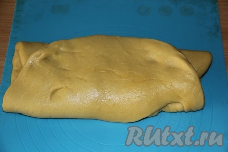Готовое тесто на силиконовом коврике (или на присыпанном мукой столе) растянуть в прямоугольный пласт и свернуть, как конверт. Несколько раз повторить процедуру растягивания теста в прямоугольный пласт и складывания конвертом.
