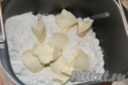 Затем всыпать муку, а сверху выложить кусочки размягченного сливочного масла, закрыть крышку хлебопечки. Для того чтобы масло было размягченным, его нужно заранее вынуть из холодильника.
