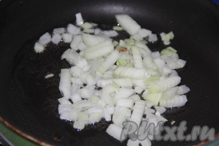 Влить в сковороду растительное масло, выложить мелко нарезанный лук и обжарить его, помешивая, до золотистого цвета.
