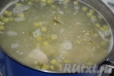 Добавить в кастрюлю солёные огурцы и варить рассольник с пшеном минут 10.
