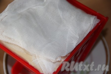 Закрыть массу марлей, свисающей с краёв формы. Поверх марли поставить блюдце и груз. Форму с творожной пасхой поставить в миску, в которую и будет стекать жидкость из творожной массы (эту жидкость нужно будет периодически сливать), и убрать в холодильник часов на 10-12.
