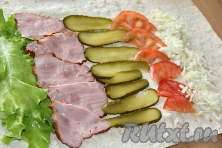 Огурчики нарезать тонкими слайсами. Помидор вымыть и тонко нарезать острым ножом. Выложить полоску огурцов (если готовите рулет со свежими огурчиками, тогда немного посолите их), а затем - полоску помидоров (как на фото). Яйцо предварительно сварить вкрутую (в течение 10 минут с момента закипания воды), затем очистить, натереть на крупной тёрке и выложить в виде полоски рядом с помидорами.
