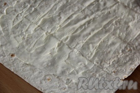 Лист лаваша смазать плавленным сыром. Края лаваша лучше не смазывать сыром.
