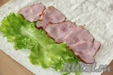 Листья салата вымыть и обсушить. Мясо для начинки тонко нарезать (я взяла буженину, но её можно заменить на вареную или копченую колбасу, ветчину и т.д.).&nbsp; Выложить листья салата полоской, начиная с края листа лаваша. Рядом выложить полоску из кусочков буженины.
