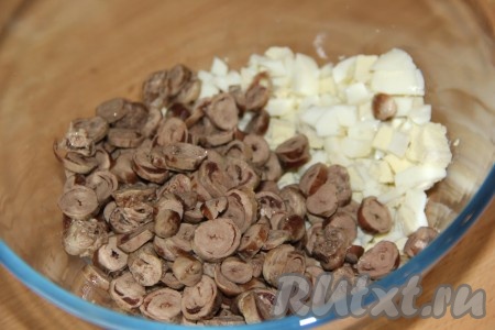 Остывшие куриные сердечки нарезать тонкими кружками и добавить к нарезанным яйцам.
