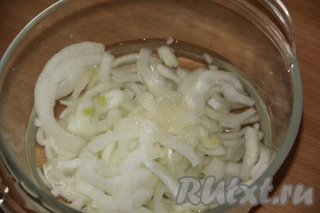 Нарезать тонкими полукольцами очищенный лук, выложить в глубокую миску, добавить сахар, уксус и воду, перемешать и оставить мариноваться на 30 минут.
