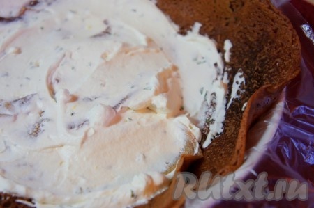 Глубокую тарелку застелить пищевой плёнкой, выложить по периметру блинчики, промазать их кремом.