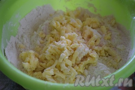 Далее охлажденное сливочное масло обмакиваем в муку и натираем на крупной терке. Натёртое масло перемешиваем с мучной смесью.
