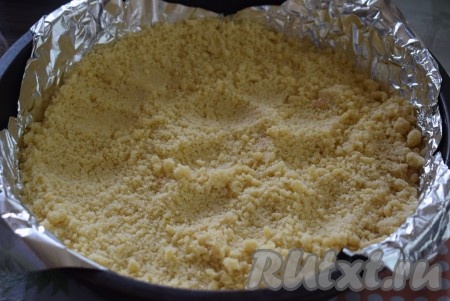 Достаем тесто из холодильника. Форму диаметром 26 см застилаем пергаментом (или фольгой). Насыпаем в форму 2/3 крошки.
