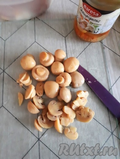 Маринованные шампиньоны нарезать тонкими пластинками, добавить в салат.
