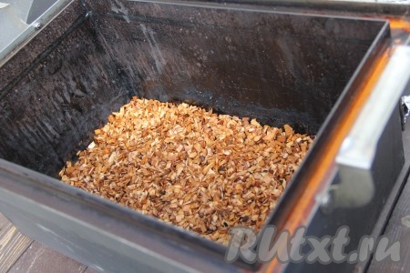 Выложить щепу на дно коптильни и разровнять.
