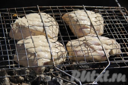 Мангал предварительно подготовить, угли должны быть горячими, без открытого огня. Замаринованные куриные бёдра выложить на решётку и поместить на мангал.
