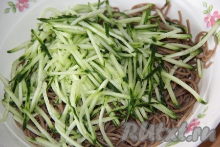 Выложить лапшу в глубокую миску, добавить огурец.