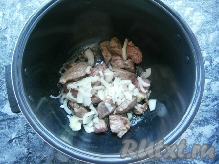 В чашу мультиварки влить растительное масло, выставить программу "Жарка" на 20 минут. Поместить в чашу мясо, обжаривать, помешивая, 5 минут, после чего добавить нарезанный произвольно репчатый лук.
