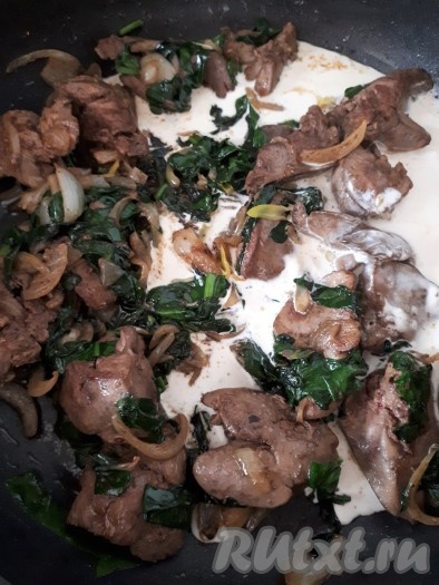 Когда шпинат уменьшится в объеме, влить сливки, перемешать и тушить куриную печень на минимальном огне 10 минут.