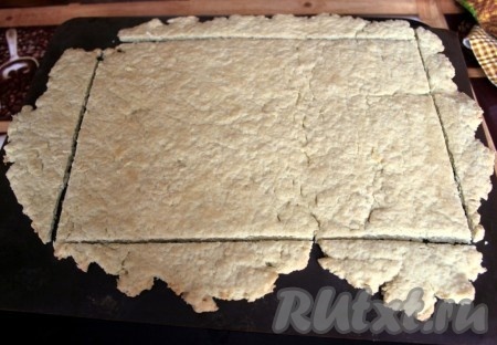 Испечь корж в разогретой духовке при 180-200 градусах около 5 минут. И пока корж тёплый, сразу подровнять его под ровный прямоугольник.