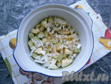 Выложить кабачки в кастрюльку (или форму), предназначенную для готовки в СВЧ, влить растительное масло и воду, посыпать мелко нарезанным луком, солью, перцем, специями и сушеным базиликом.
