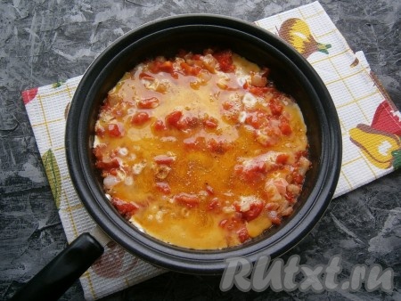 Обжаривать овощи, помешивая, на небольшом огне до тех пор, пока большая часть жидкости не испарится. После этого вылить в сковороду яичную смесь, посолить, посыпать специями и красным молотым перцем.
