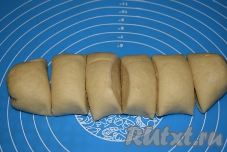 Приступим к лепке пицц-чебуреков. Достаём тесто. Отдохнувшее тесто станет очень мягким и податливым, с ним будет очень легко работать. Скатаем из теста колбаску, разрежем её на 6 равных частей.
