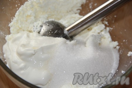 Затем к творогу всыпать сахар и добавить сметану.
