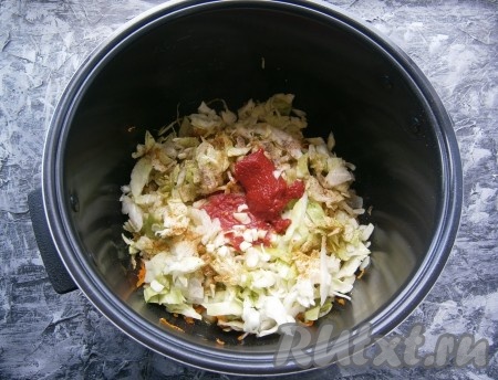 После сигнала добавить в чашу нашинкованную капусту, соль, специи, чёрный молотый перец, измельченный чеснок и томатную пасту, влить горячую воду (или бульон).
