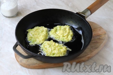 Столовой ложкой выложить порции теста на разогретую с растительным маслом сковороду, формируя круглые (или овальные) оладьи.&nbsp;
