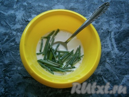 В мучную смесь влить ледяную воду, замесить венчиком довольно жидкое однородное тесто. Добавить в него большую часть зеленого лука, перемешать тесто.
