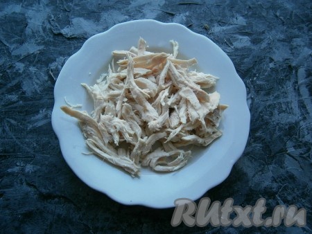 Куриное филе, отваренное в течение 35-40 минут в подсоленной воде, остудить, разделить на волокна.
