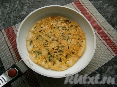 Сковороду накрыть крышкой, огонь убавить до минимального и жарить лепёшку около 3-5 минут. Сверху тесто не должно остаться жидким. Затем картофельную лепёшку перевернуть.
