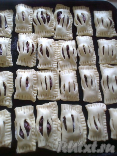 Вилкой соединяем края слойки, как на фото, прижимая тесто по краям. Выкладываем слойки на противень, смазанный растительным маслом (или застеленный пергаментом).
