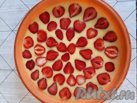 Для приготовления штрейзеля соединить муку, сахар и сливочное масло и перетереть руками до образования крошки. Переложить подготовленное тесто в форму, смазанную маслом. У меня силиконовая форма диаметром 26 см, поэтому я её ничем не смазывала. Клубнику разрезать на половинки (четвертинки) и выложить на тесто.