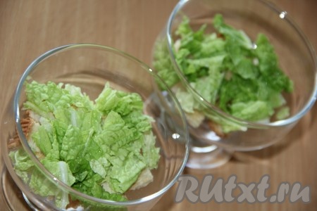 Листья пекинской капусты вымыть, обсушить, порвать на достаточно крупные кусочки. Поверх сухариков выложить половину пекинской капусты.
